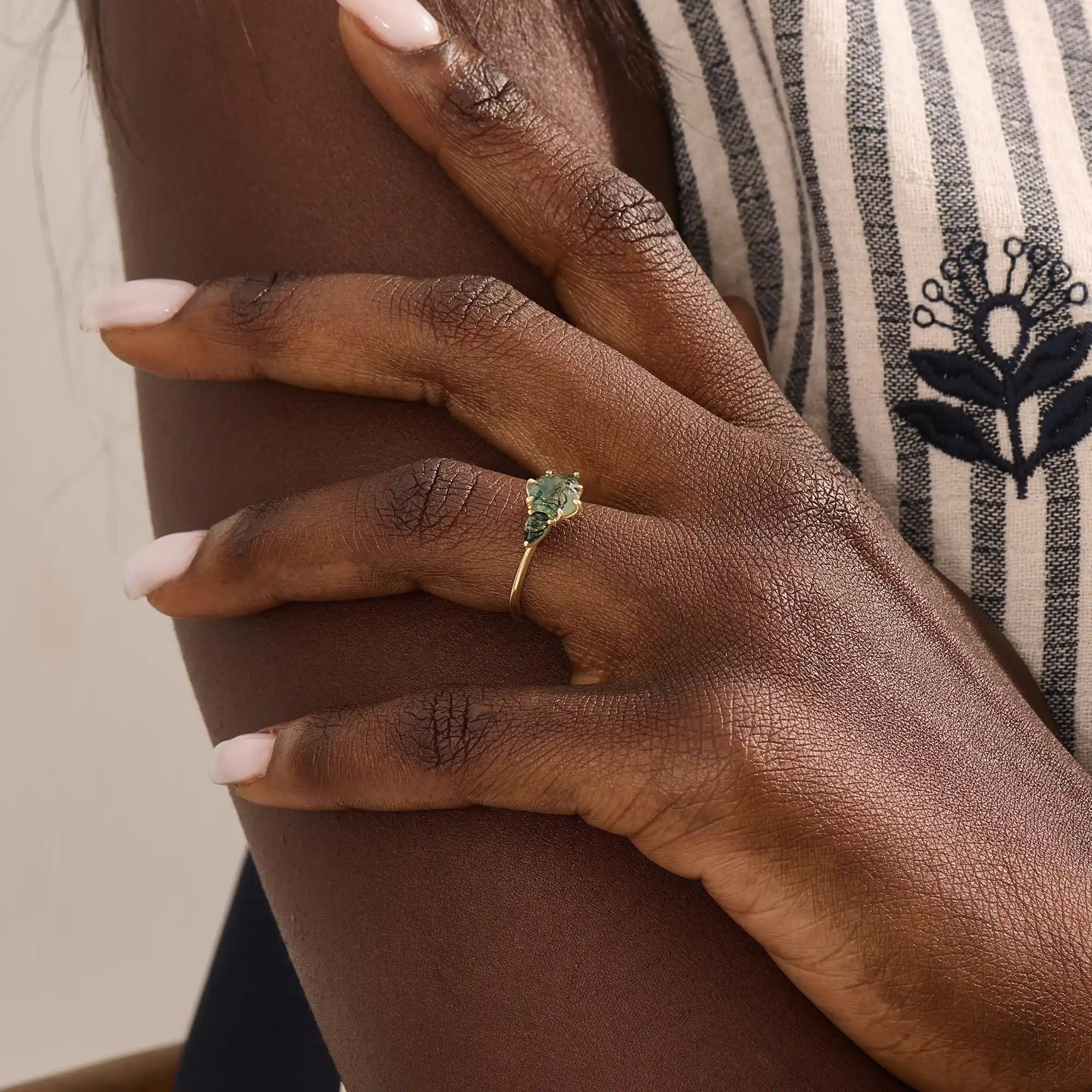 Model wears a 14k solid gold chunky ring featuring a natural moss agate gemstone. Bold and organic anniversary style.