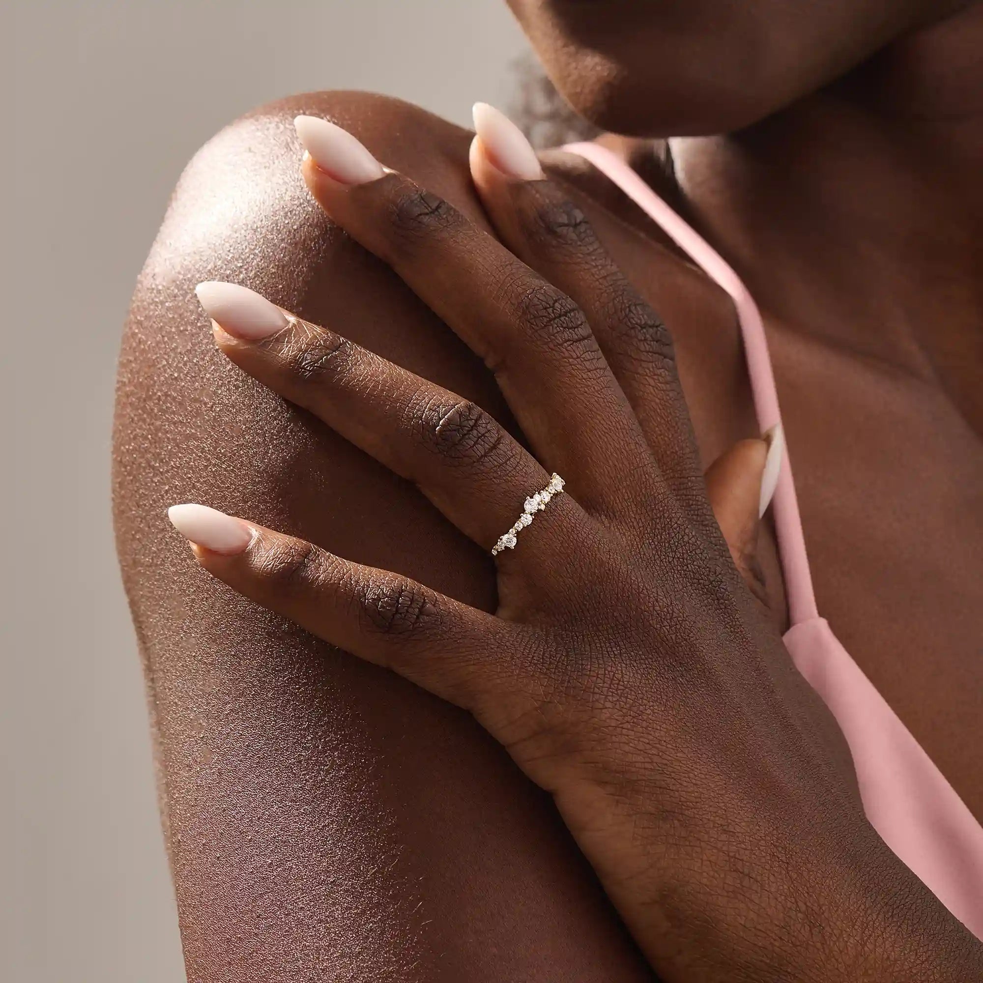 Model wears a 14k solid gold curved stackable wedding ring featuring cluster-pave moissanites. Elegant and versatile piece for layering or bridal wear.