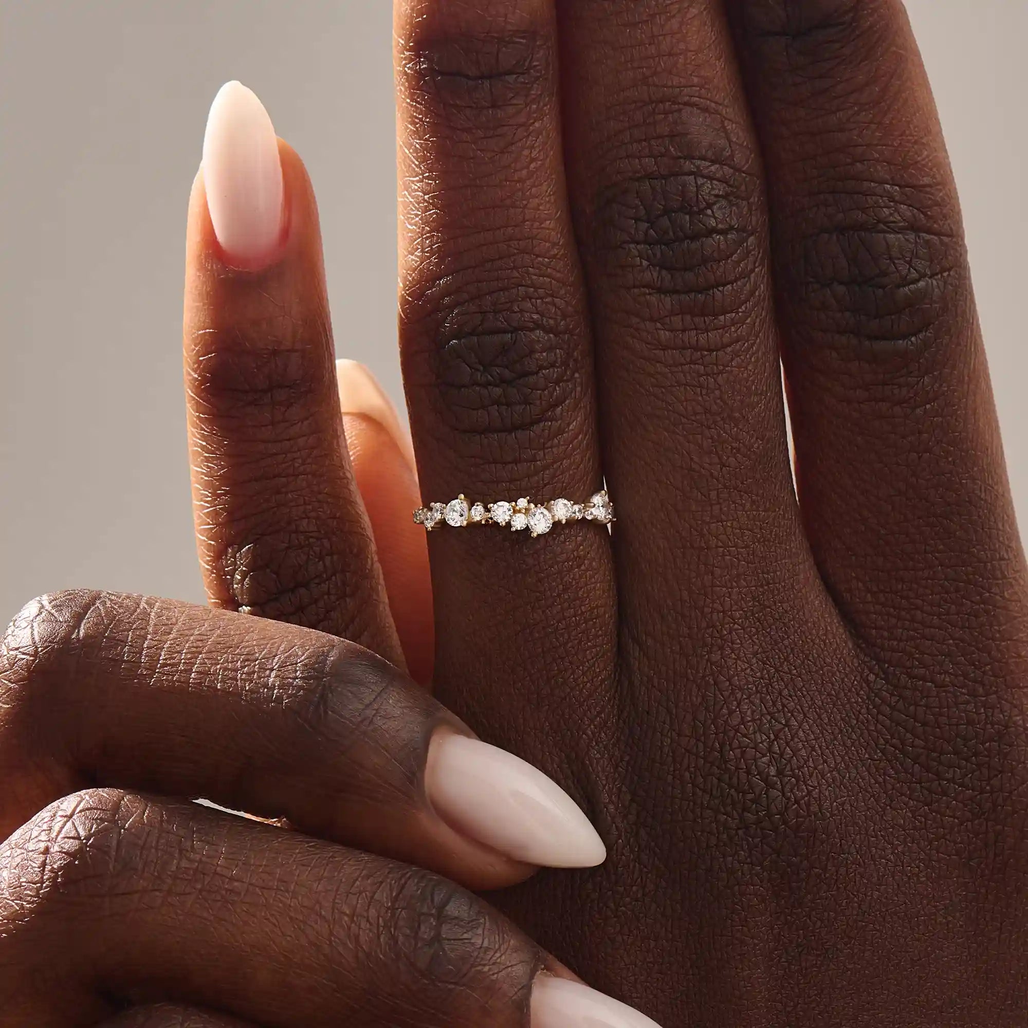 Model wears a 14k solid gold curved stackable wedding ring featuring cluster-pave moissanites. Elegant and versatile piece for layering or bridal wear.