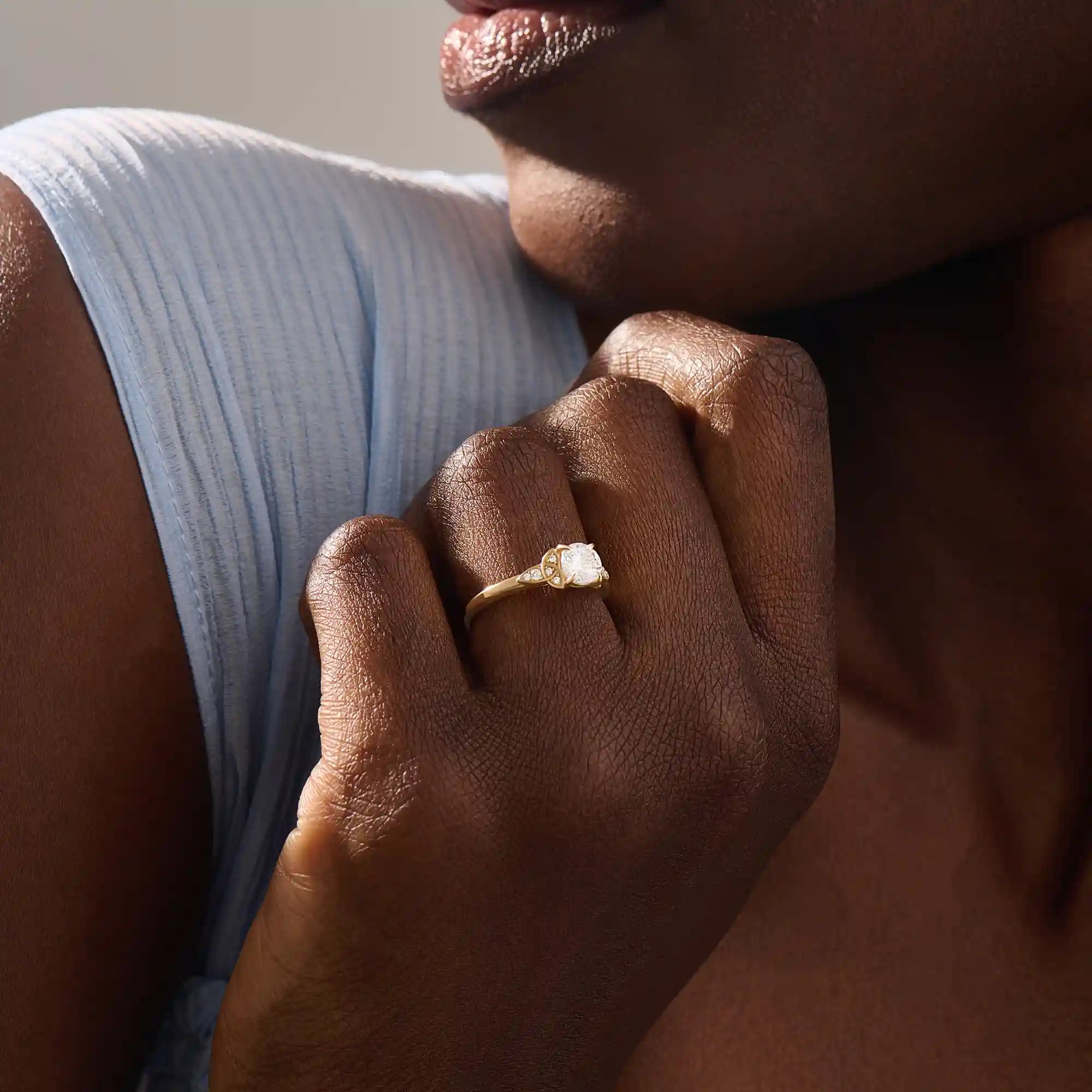 Model wears a 14k solid gold solitaire engagement ring with Celtic knot detailing and accent moissanites. Elegant and meaningful statement bridal jewelry.