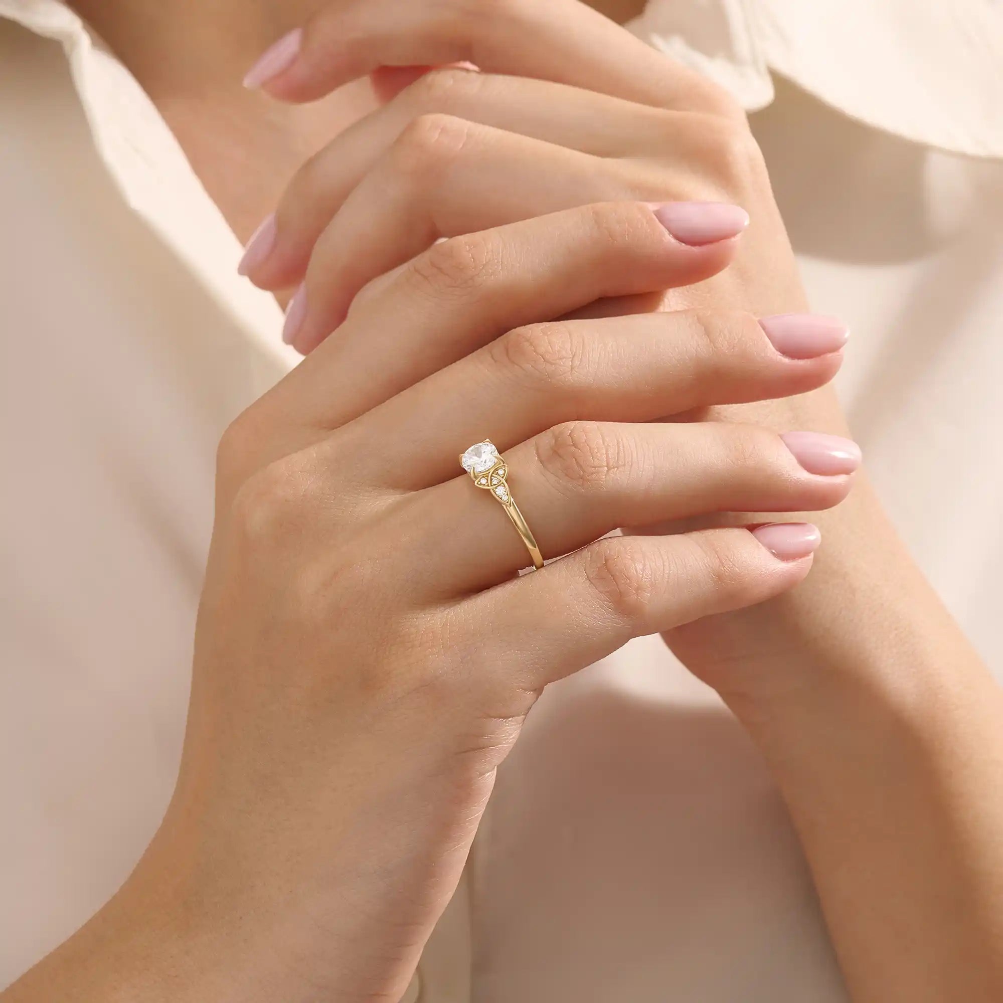 Model wears a 14k solid gold solitaire engagement ring with Celtic knot detailing and accent moissanites. Elegant and meaningful statement bridal jewelry.