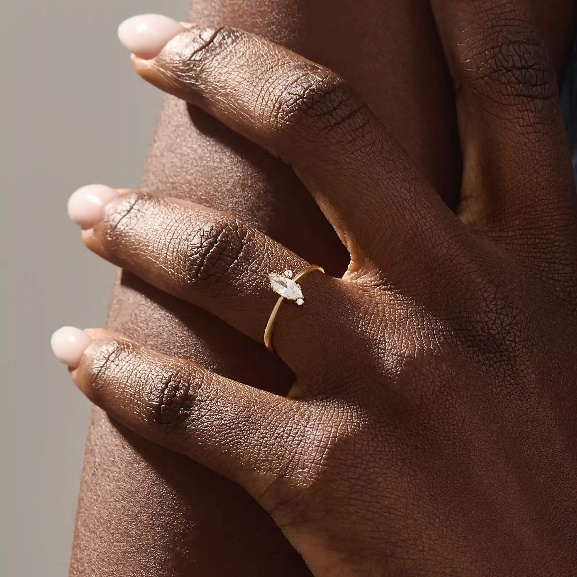 Model wears a 14k solid gold solitaire engagement ring with a marquise-cut moissanite. Minimalist and refined style, perfect for everyday bridal wear.