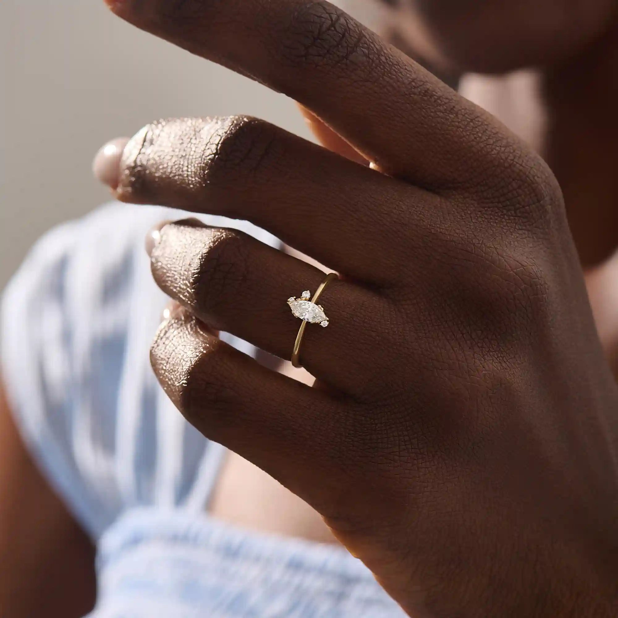 Model wears a 14k solid gold solitaire engagement ring with a marquise-cut moissanite. Minimalist and refined style, perfect for everyday bridal wear.