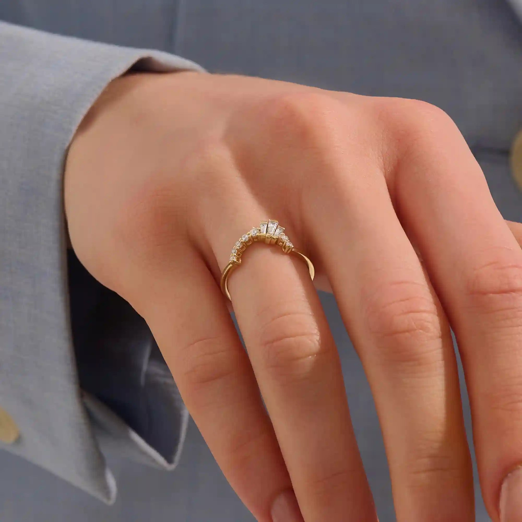 Model wears a curved gold ring adorned with baguette moissanites in an arch design. Sleek and contemporary, perfect for layering with solitaires.