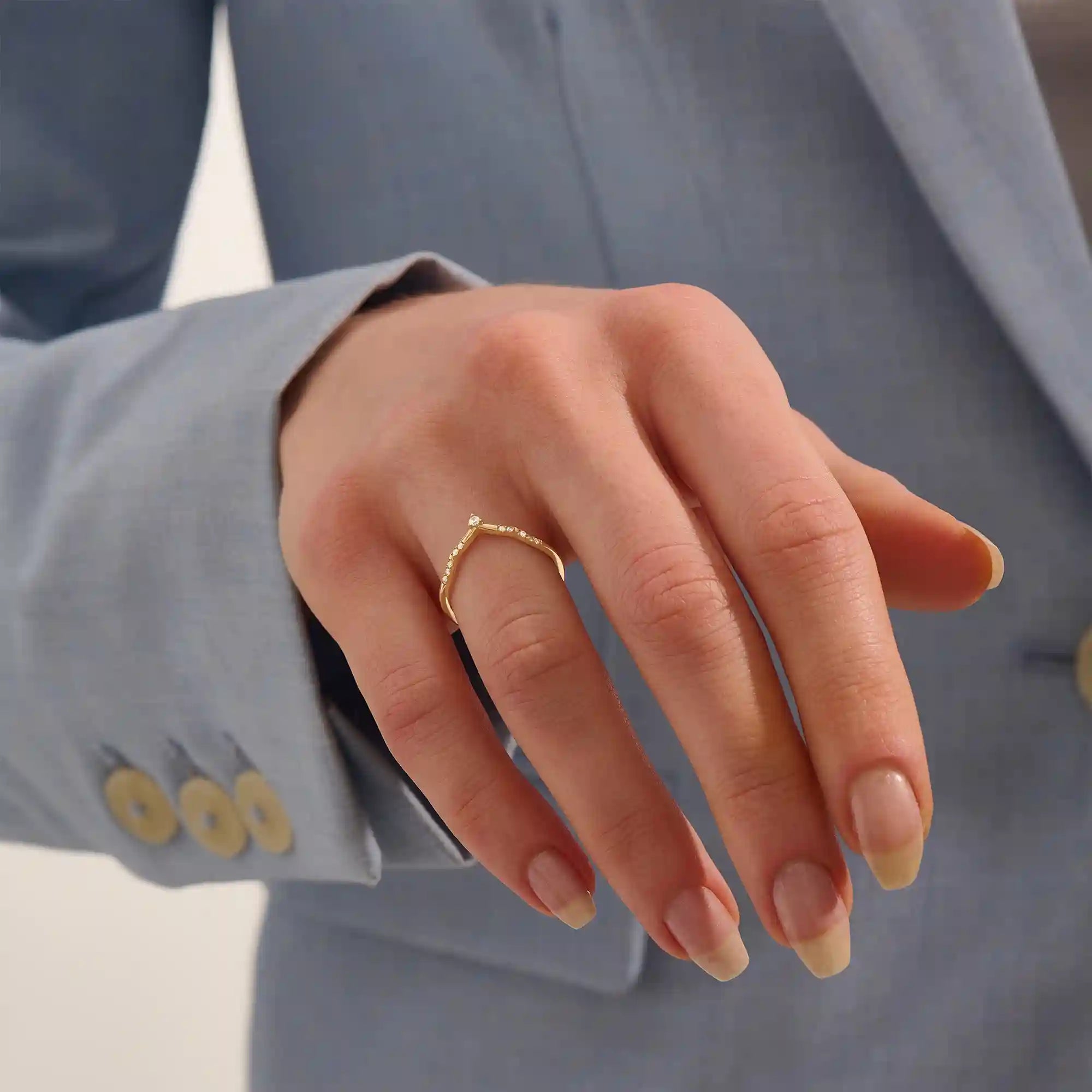 Model wears a dainty chevron curve ring with pavé moissanites in 14k gold. Ideal for stacking or pairing with a solitaire engagement ring.