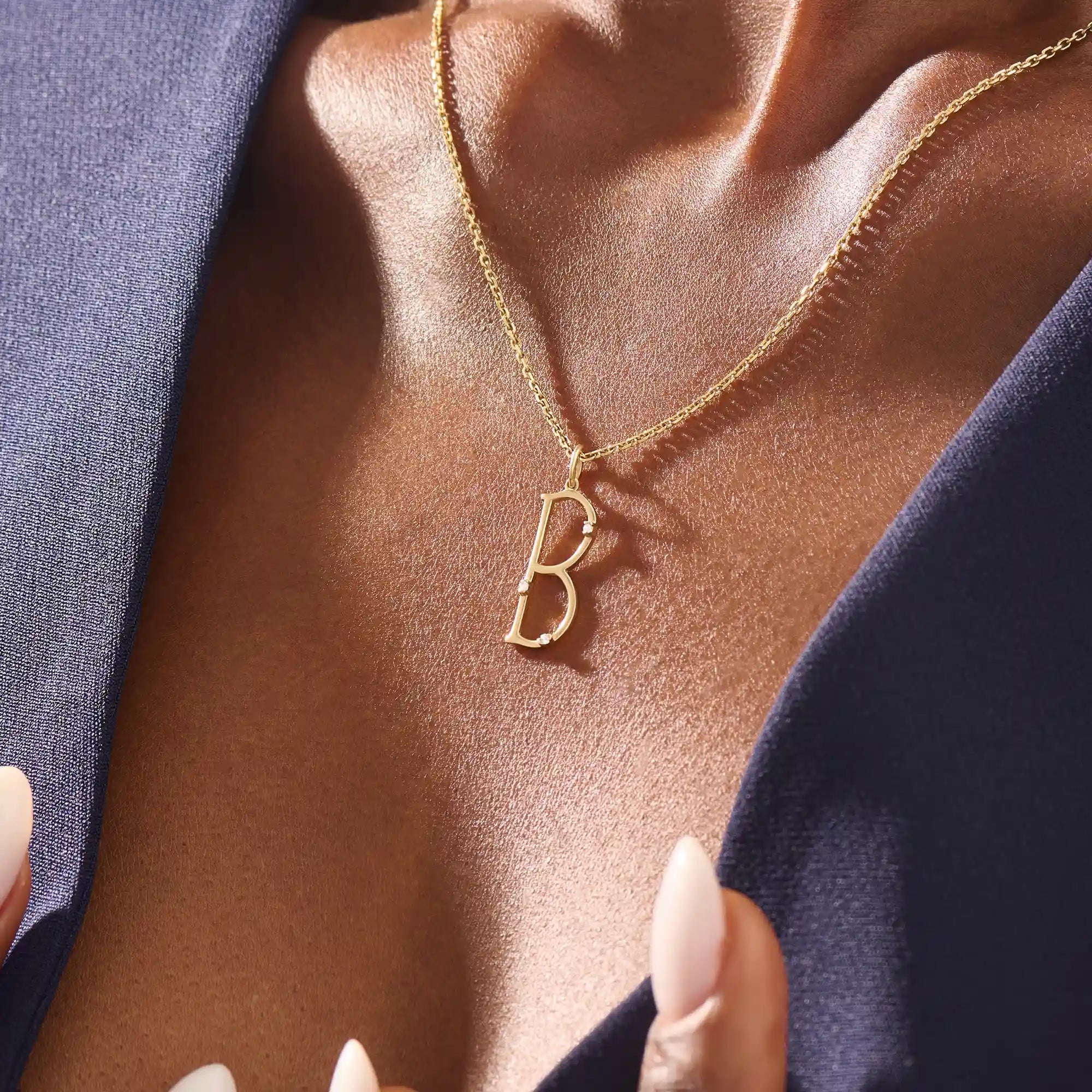 Model wears a slim 14k gold initial necklace featuring dainty moissanites. Elegant and minimal, perfect for layering or gifting.