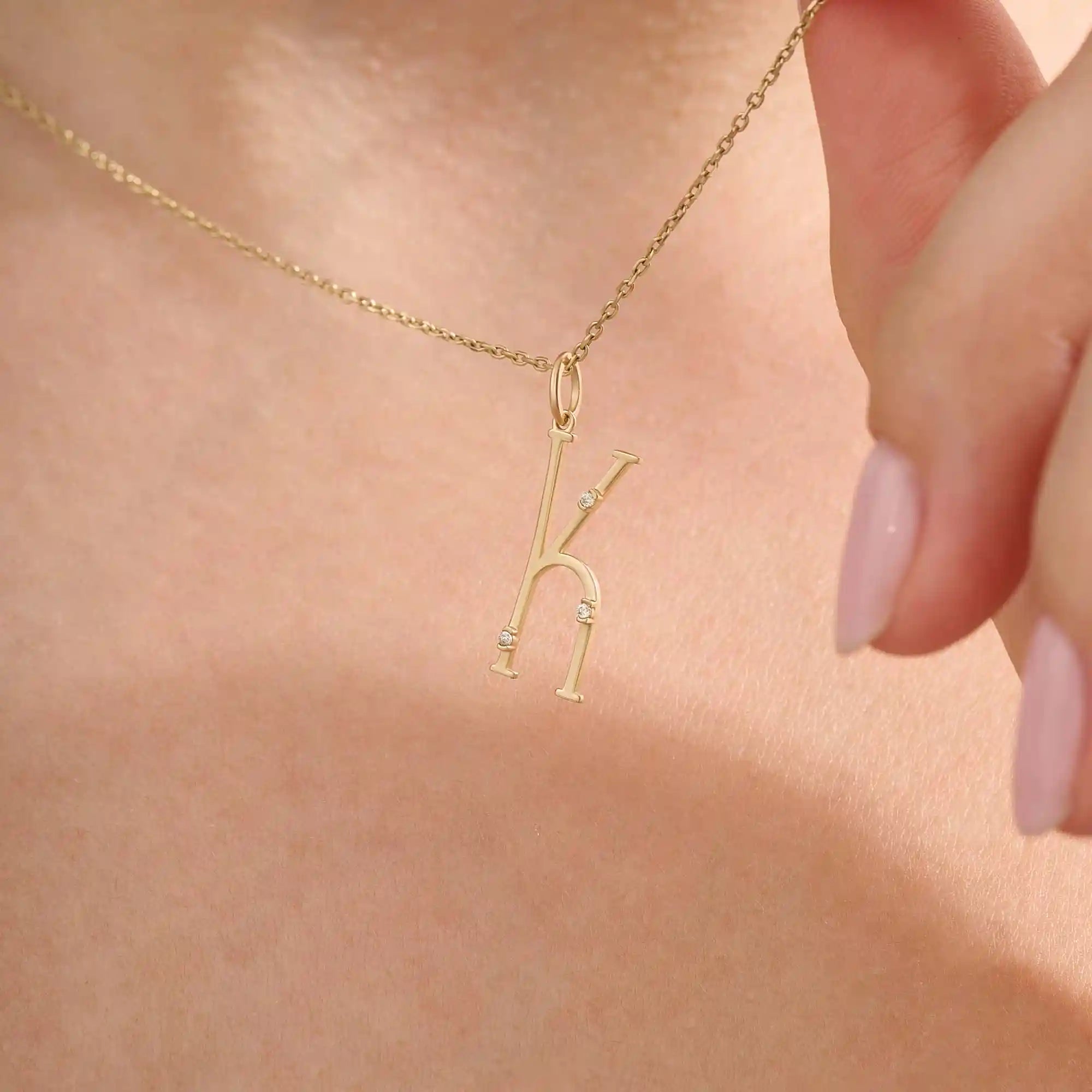 Model wears a slim 14k gold initial necklace featuring dainty moissanites. Elegant and minimal, perfect for layering or gifting.