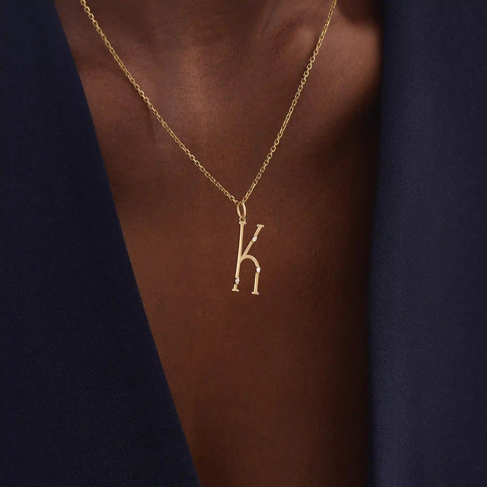 Model wears a slim 14k gold initial necklace featuring dainty moissanites. Elegant and minimal, perfect for layering or gifting.