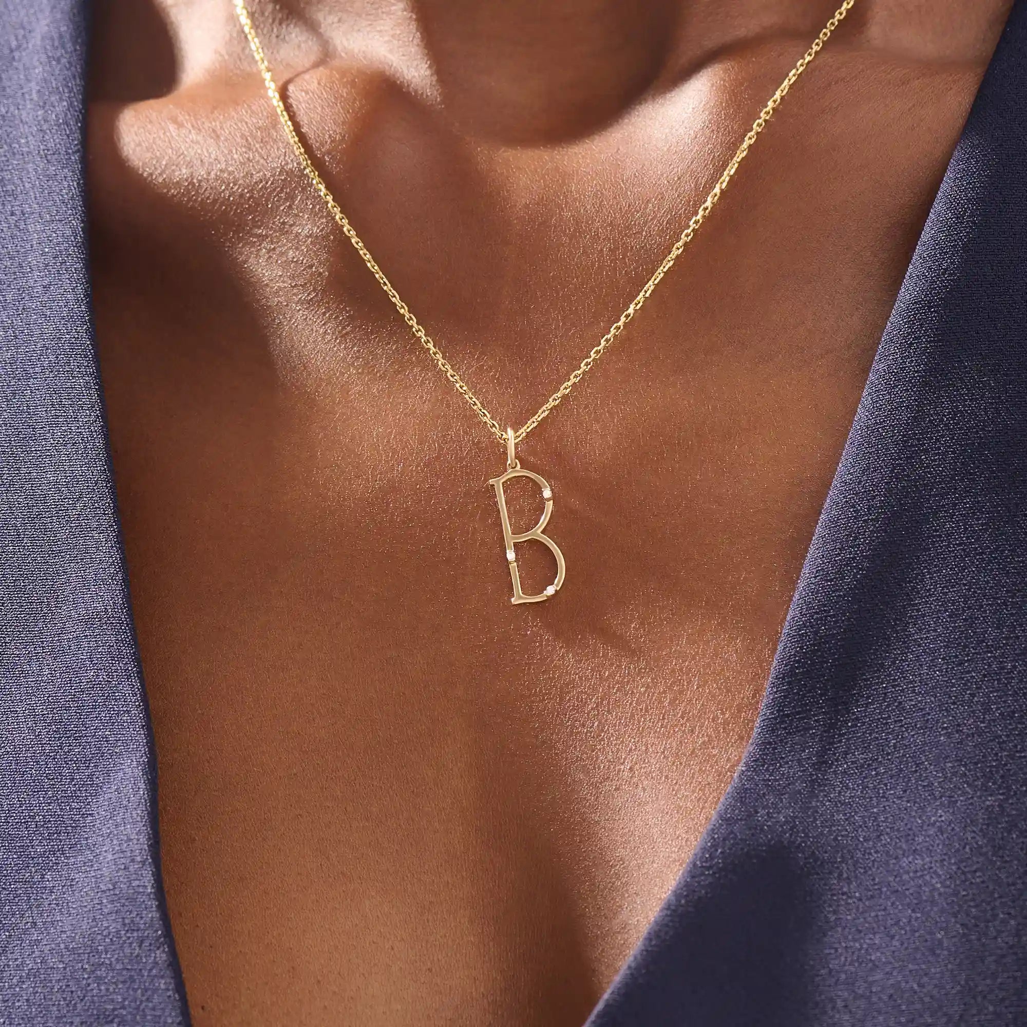 Model wears a slim 14k gold initial necklace featuring dainty moissanites. Elegant and minimal, perfect for layering or gifting.