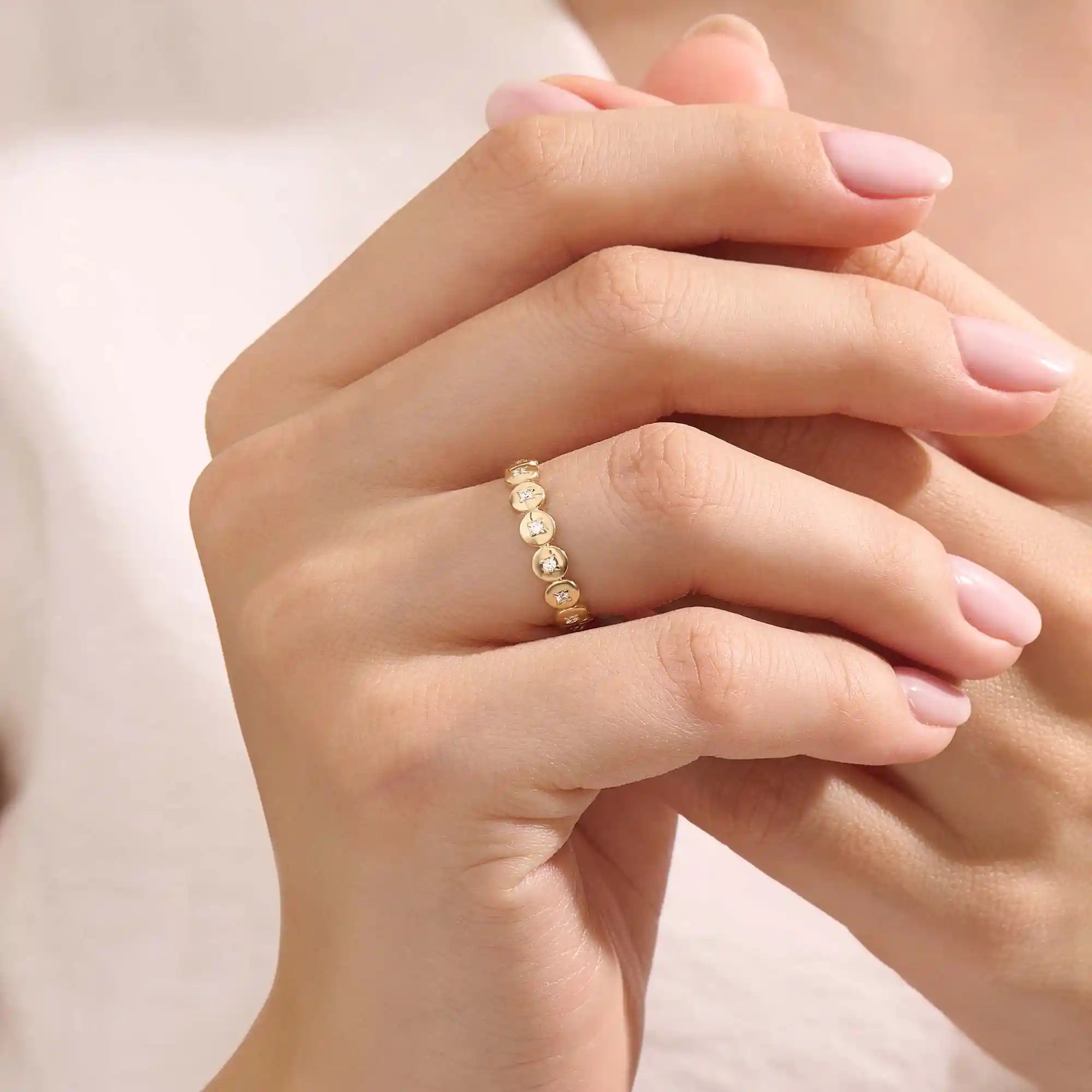 Model wears a striking 14k gold eternity ring with linked circle motifs. Perfect as a meaningful band or a modern statement ring.
