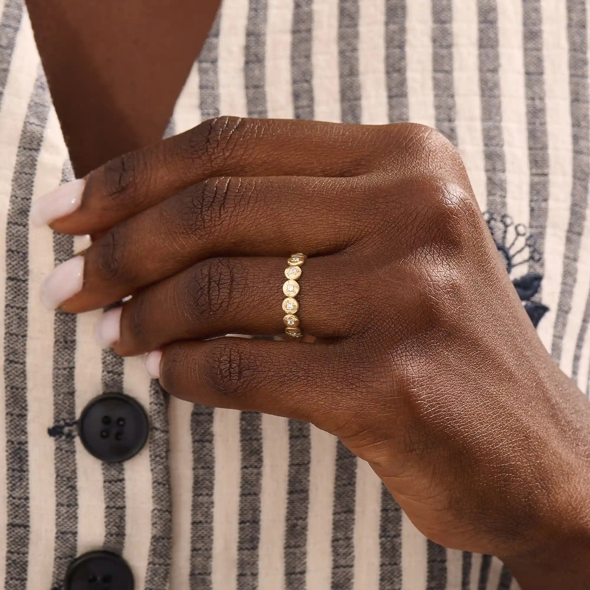 Model wears a striking 14k gold eternity ring with linked circle motifs. Perfect as a meaningful band or a modern statement ring.