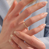 Model wears a uniquely designed 14k gold stacking ring. Adds elegant texture and style to layered ring looks.
