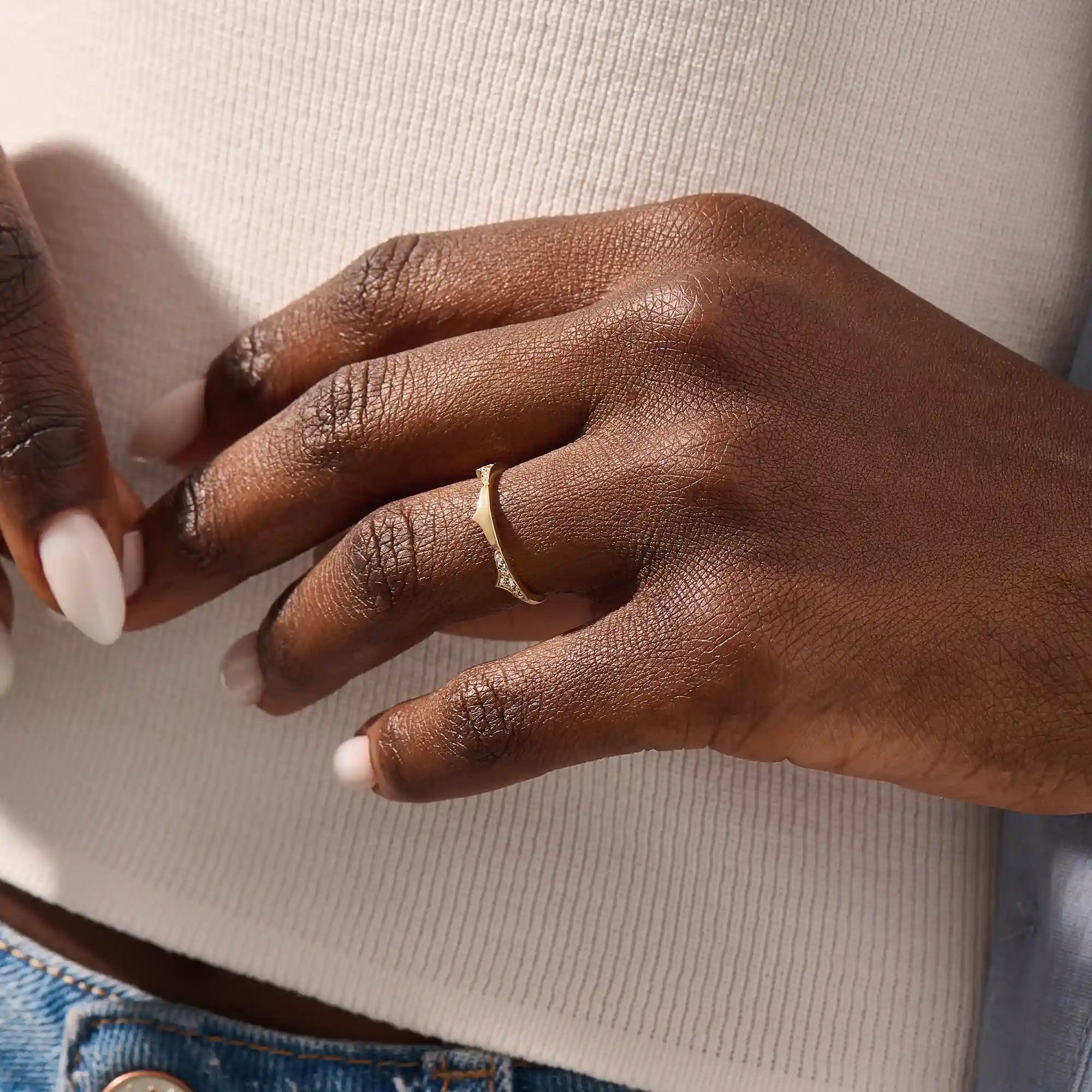 Model wears a uniquely designed 14k gold stacking ring. Adds elegant texture and style to layered ring looks.