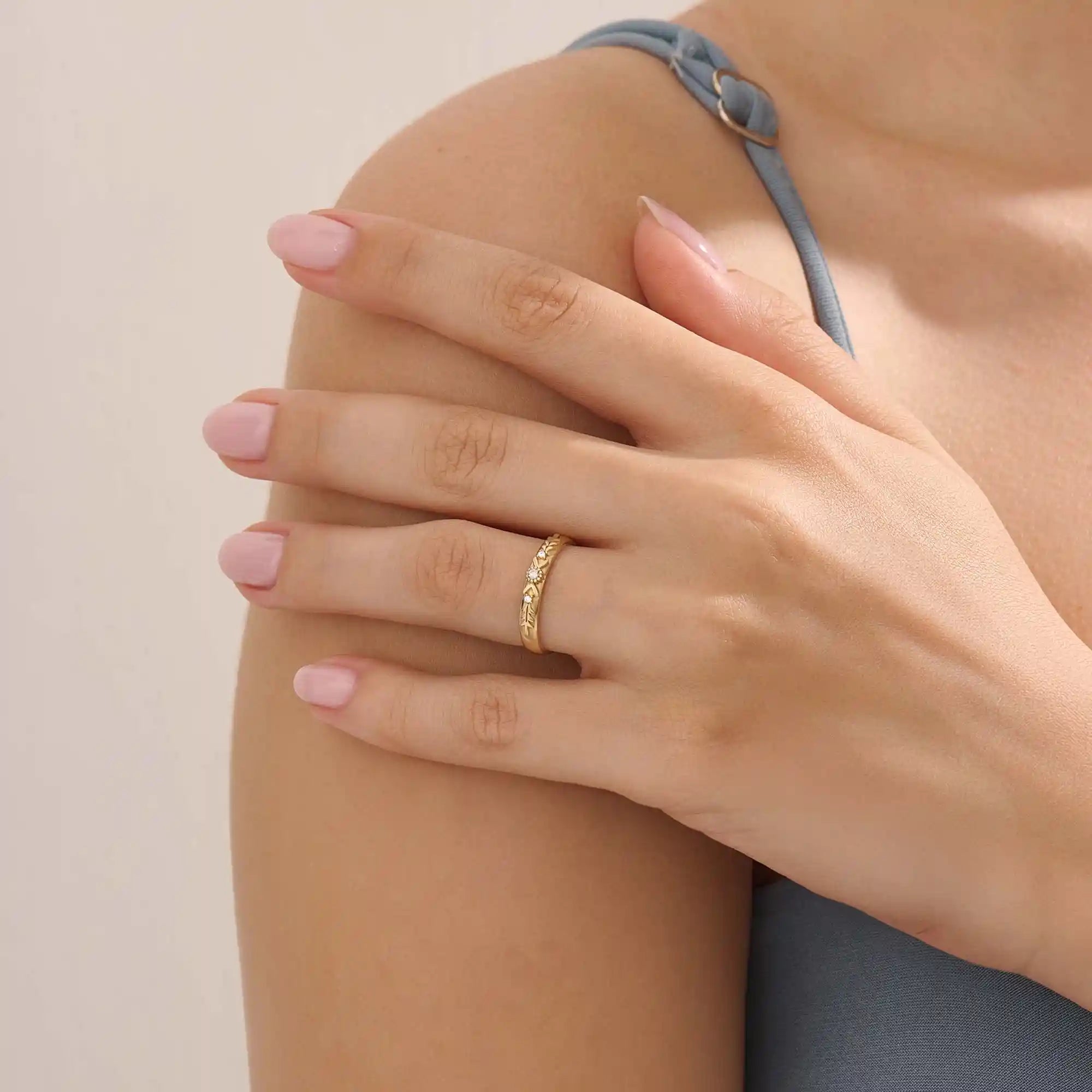 Model wears a vintage design 14k gold leaf band promise ring featuring detailed leaf engravings. Perfect for meaningful everyday wear or gifting.