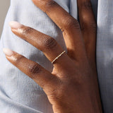Model wears an ultra thin gold beaded band stacking ring. A subtle and elegant piece ideal for everyday wear and stacking.