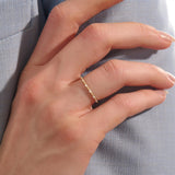 Model wears an ultra thin gold beaded band stacking ring. A subtle and elegant piece ideal for everyday wear and stacking.