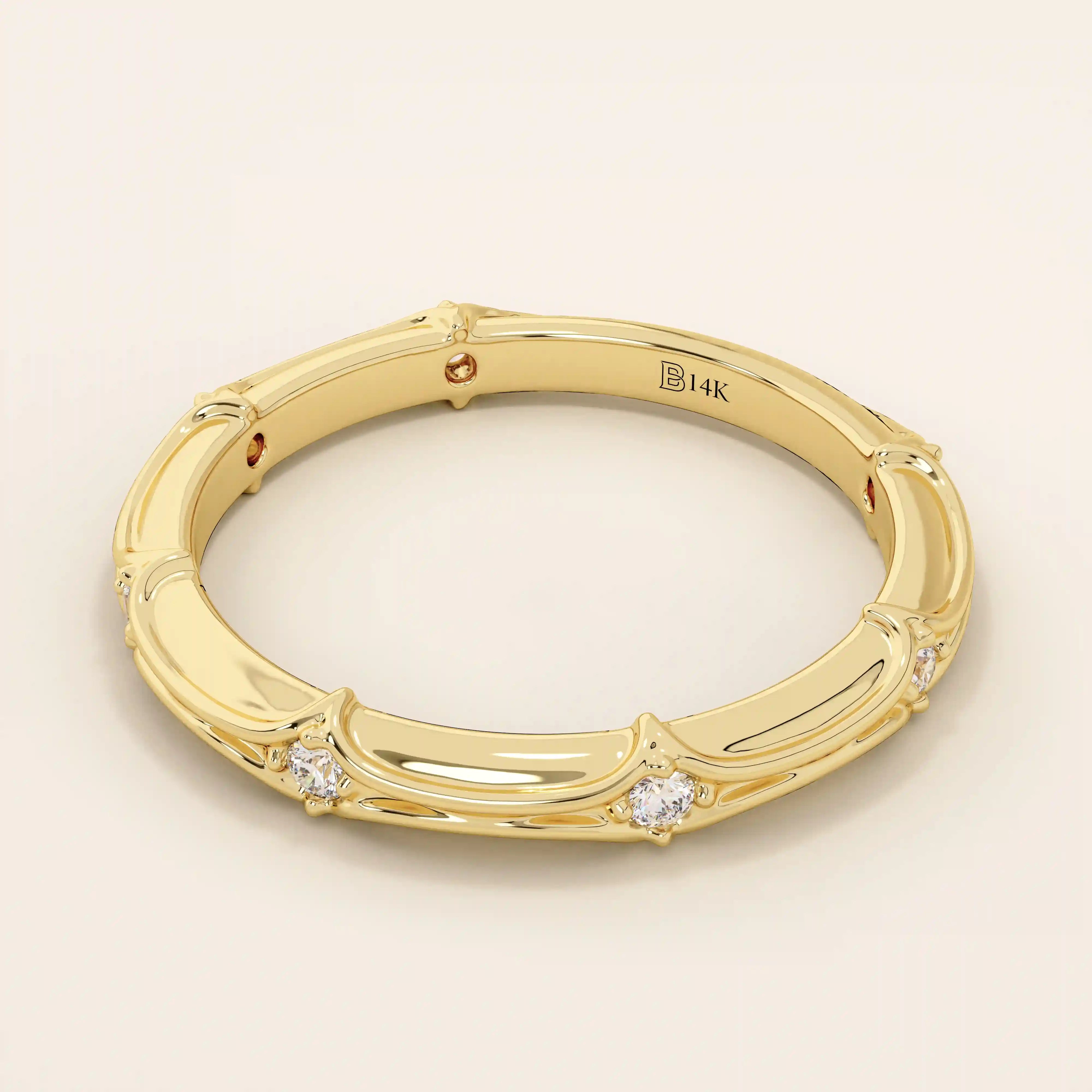 Side angle view of a 14k solid yellow gold bamboo-inspired wedding band with round brilliant-cut moissanites in a spaced setting
