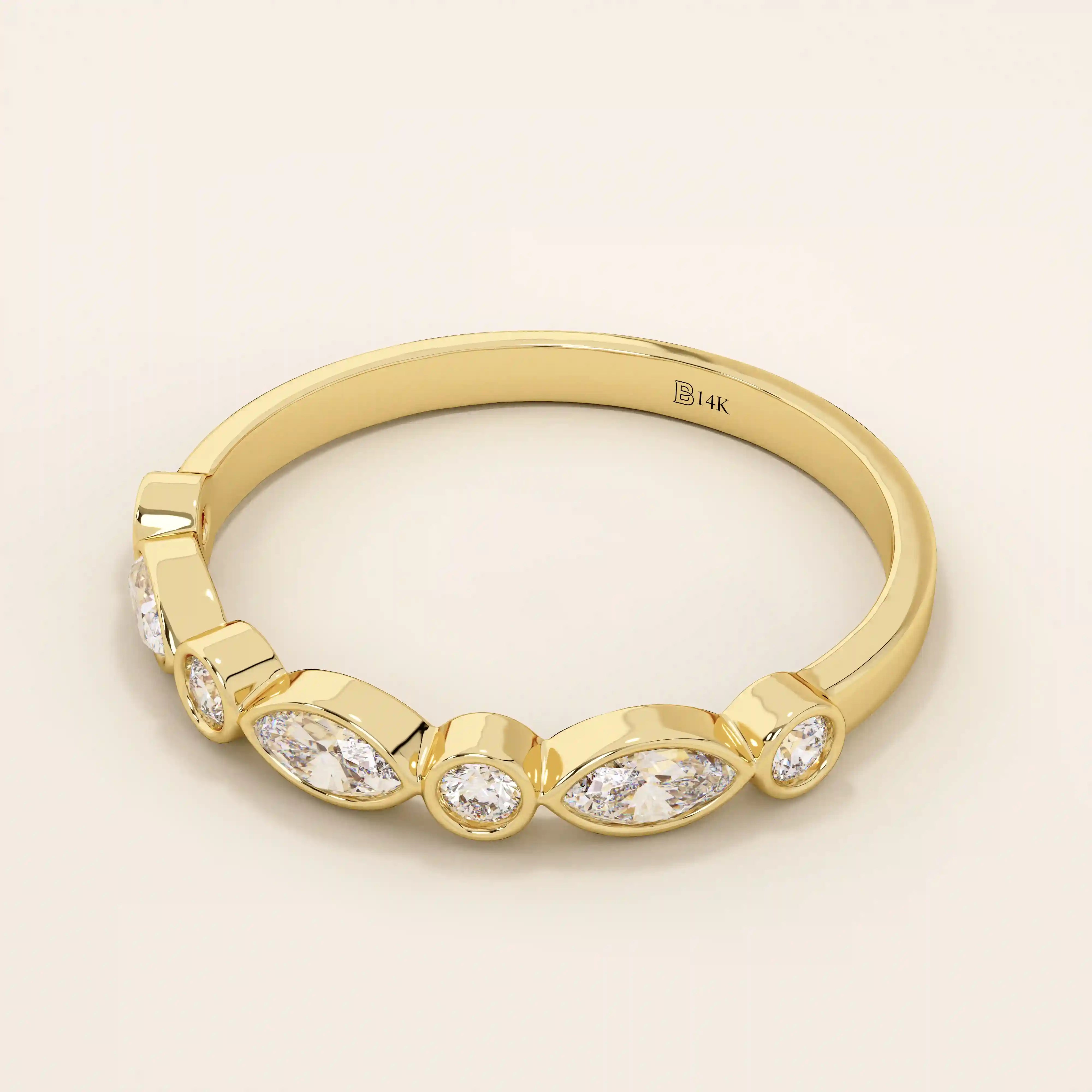 Side angle view of a 14k solid yellow gold band with alternating marquise cut and round brilliant cut moissanite stones in a smooth bezel setting, sophisticated wedding or stacking ring