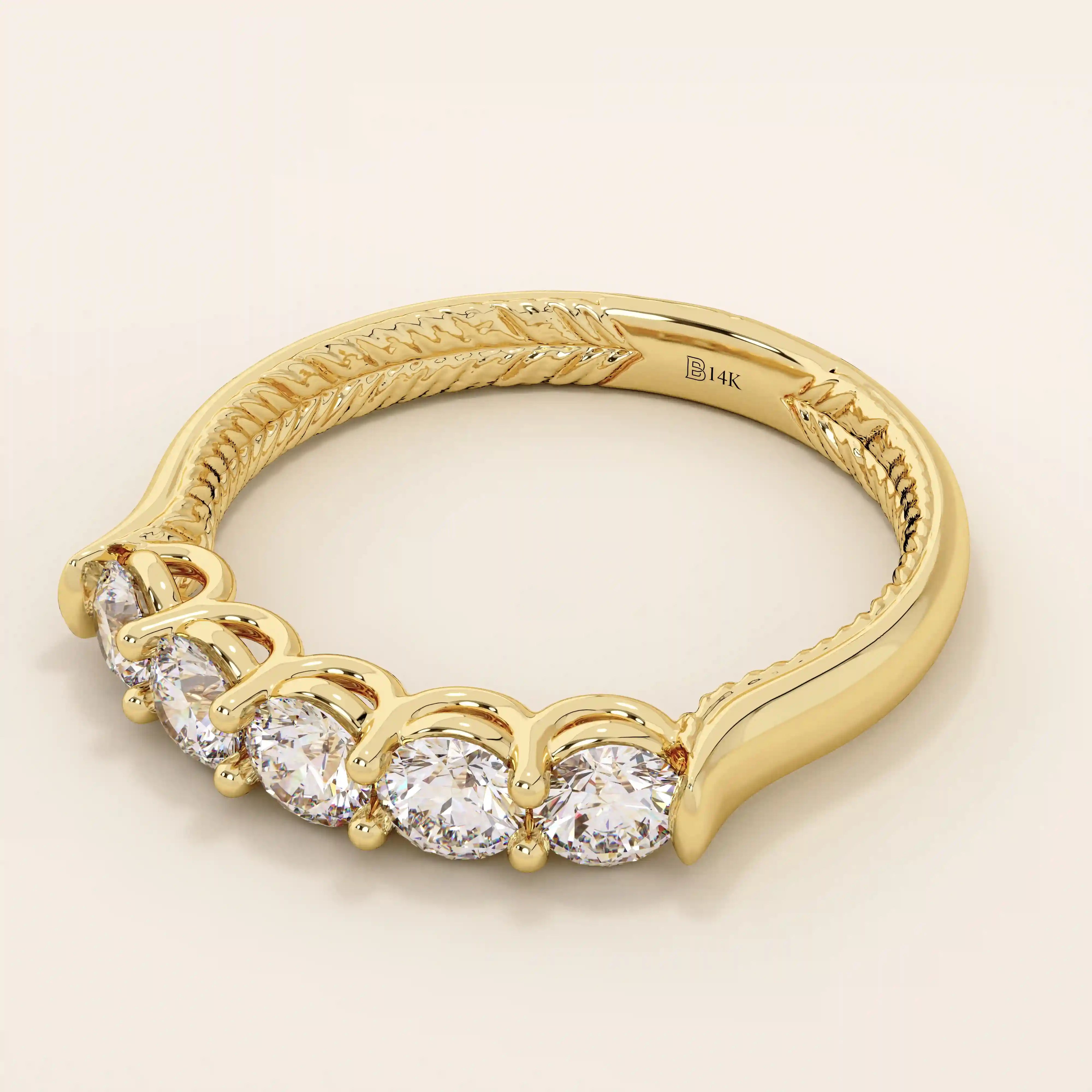 Side angle view of a 14k solid yellow gold band with five round brilliant cut moissanite stones in a prong setting and engraved shank detail, classic and elegant bridal jewelry