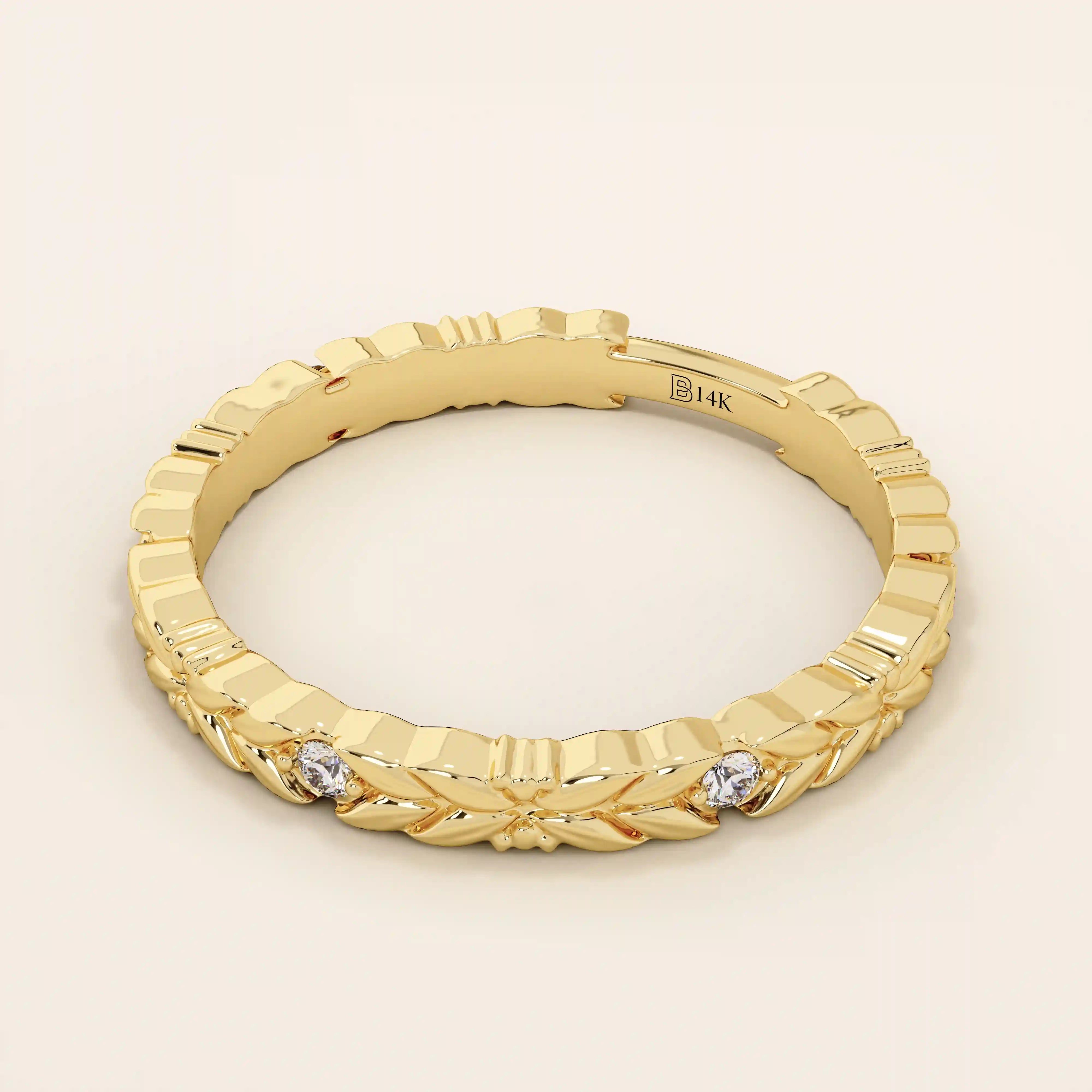 Side angle view of a 14k solid yellow gold band with laurel leaf design and bezel set round brilliant cut moissanite stones, refined and unique bridal jewelry
