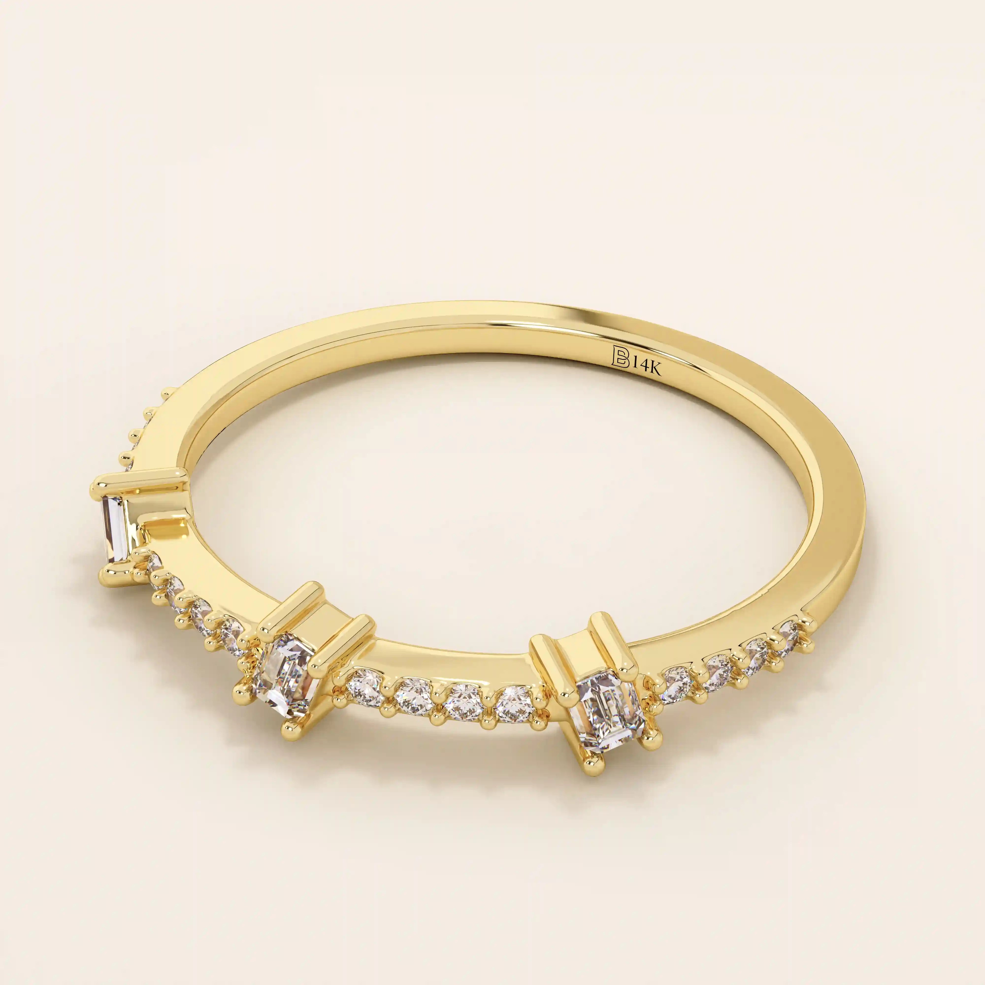 Side angle view of a 14k solid yellow gold band with three baguette cut moissanite stones and pavé set round moissanite accents, minimal and refined bridal jewelry