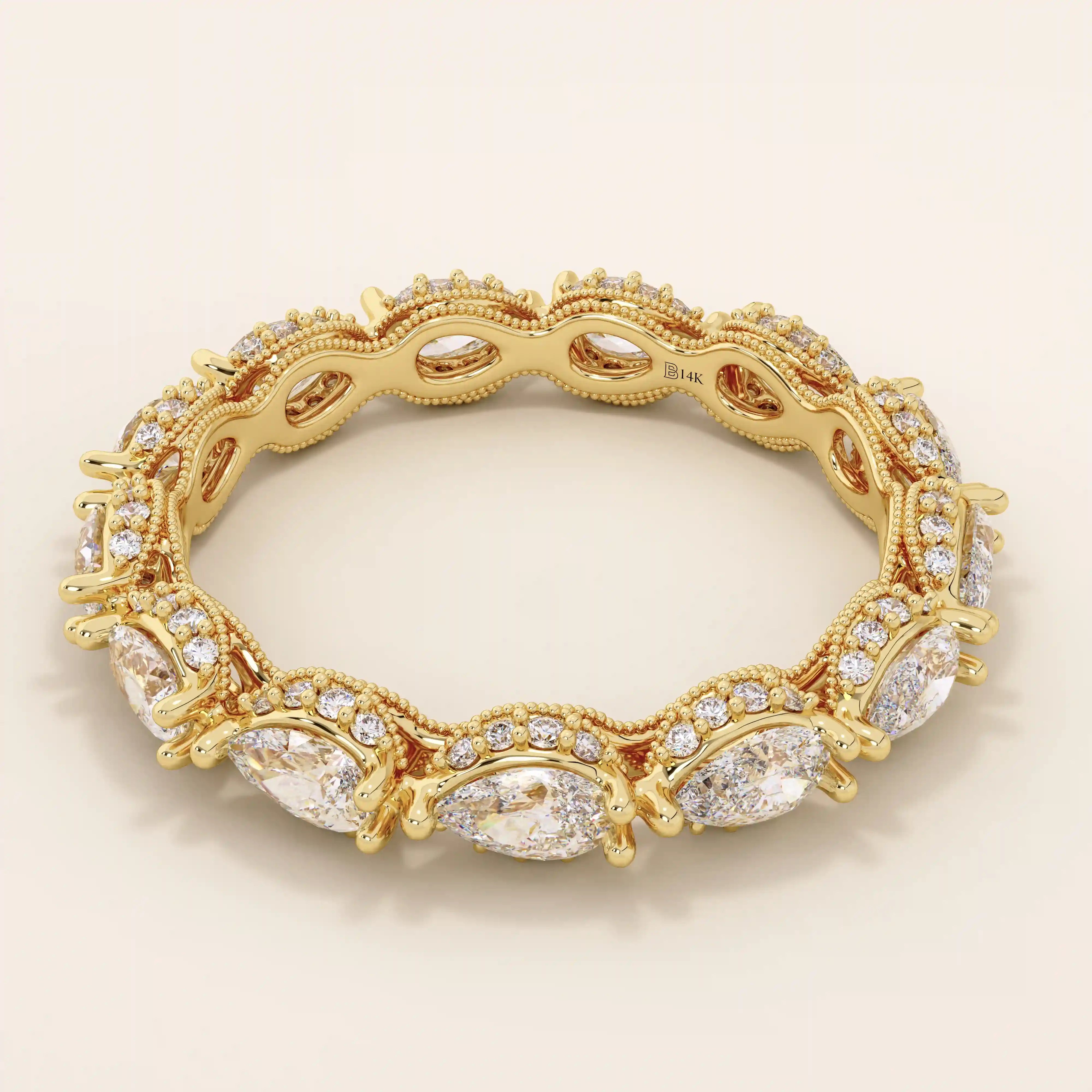 Side angle view of a 14k solid yellow gold eternity band with sideways pear cut moissanite stones and pavé set round moissanite accents, finished with detailed milgrain edges for an opulent bridal look