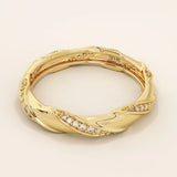 Side angle view of a 14k solid yellow gold twist eternity wedding band with rows of sparkling moissanites in an elegant sculpted design