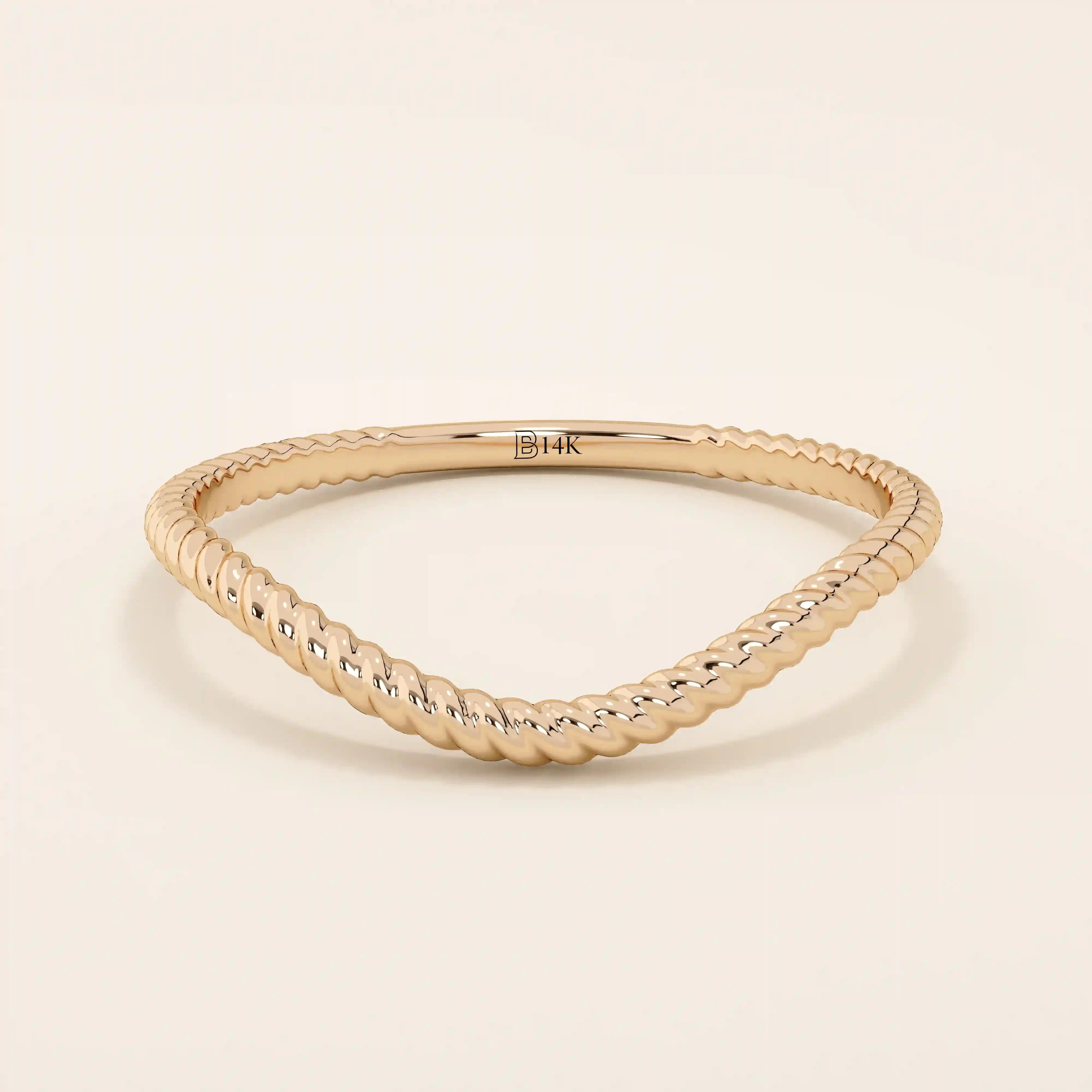 Slim curved stacking ring in 14k solid gold with a delicate twisted band. Designed to nest with engagement rings or wear alone for subtle texture.