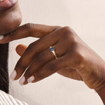 Woman wearing a 14k gold ring with a deep blue oval sapphire. A refined and classic gemstone ring, ideal as a gift or statement piece.
