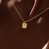 Woman wearing a 14k solid gold dainty octagon pendant necklace. Lightweight and easy-to-style gold charm. Perfect for daily looks or as a layering piece.