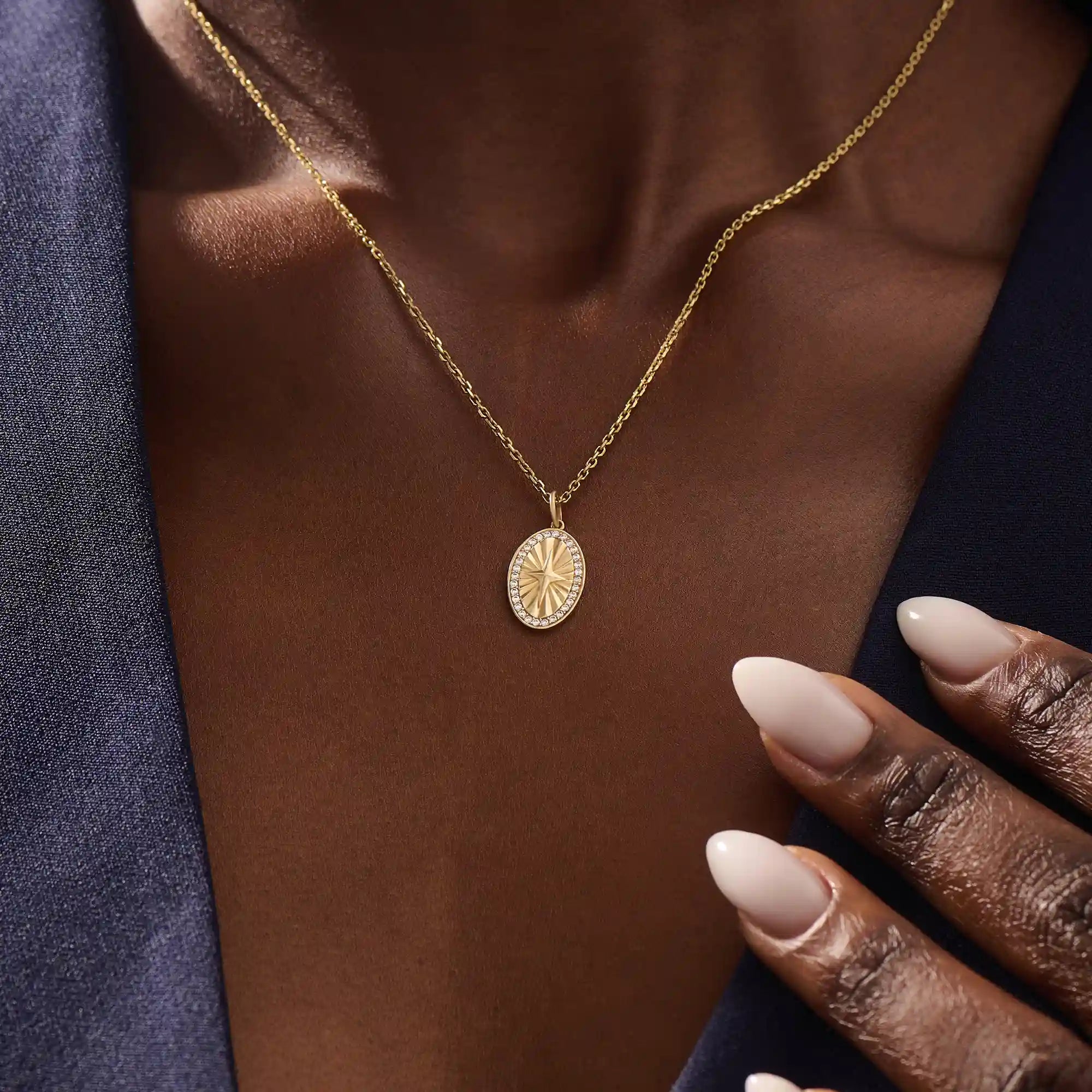 Woman wearing a 14k solid gold oval compass necklace featuring pave moissanite accents and a central 4-point star. Minimalist and meaningful pendant necklace. Ideal for layering or gifting.