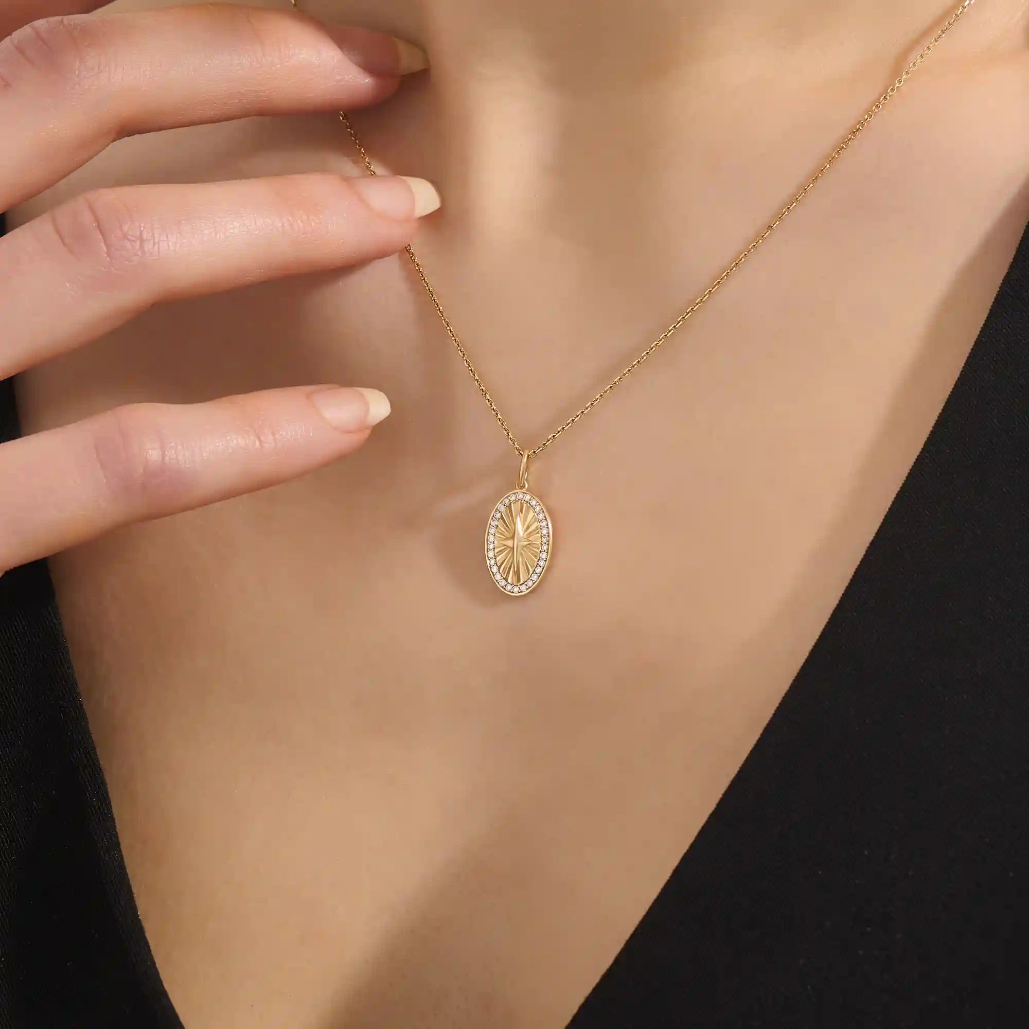 Woman wearing a 14k solid gold oval compass necklace featuring pave moissanite accents and a central 4-point star. Minimalist and meaningful pendant necklace. Ideal for layering or gifting.