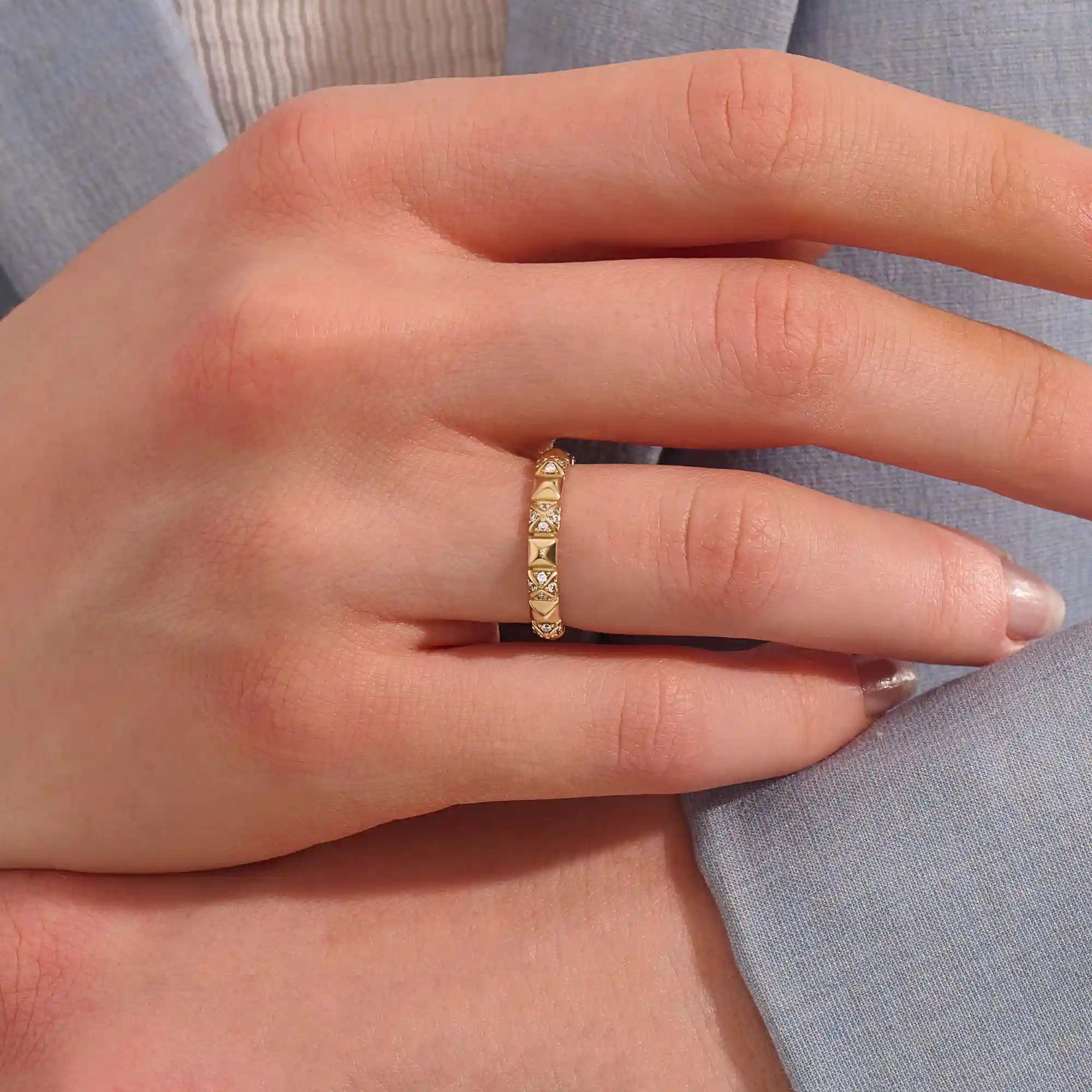 Woman wearing a 14k solid gold pyramid-style band with shimmering pave moissanites. A unique and structured gold ring. Ideal for weddings or everyday elegance.