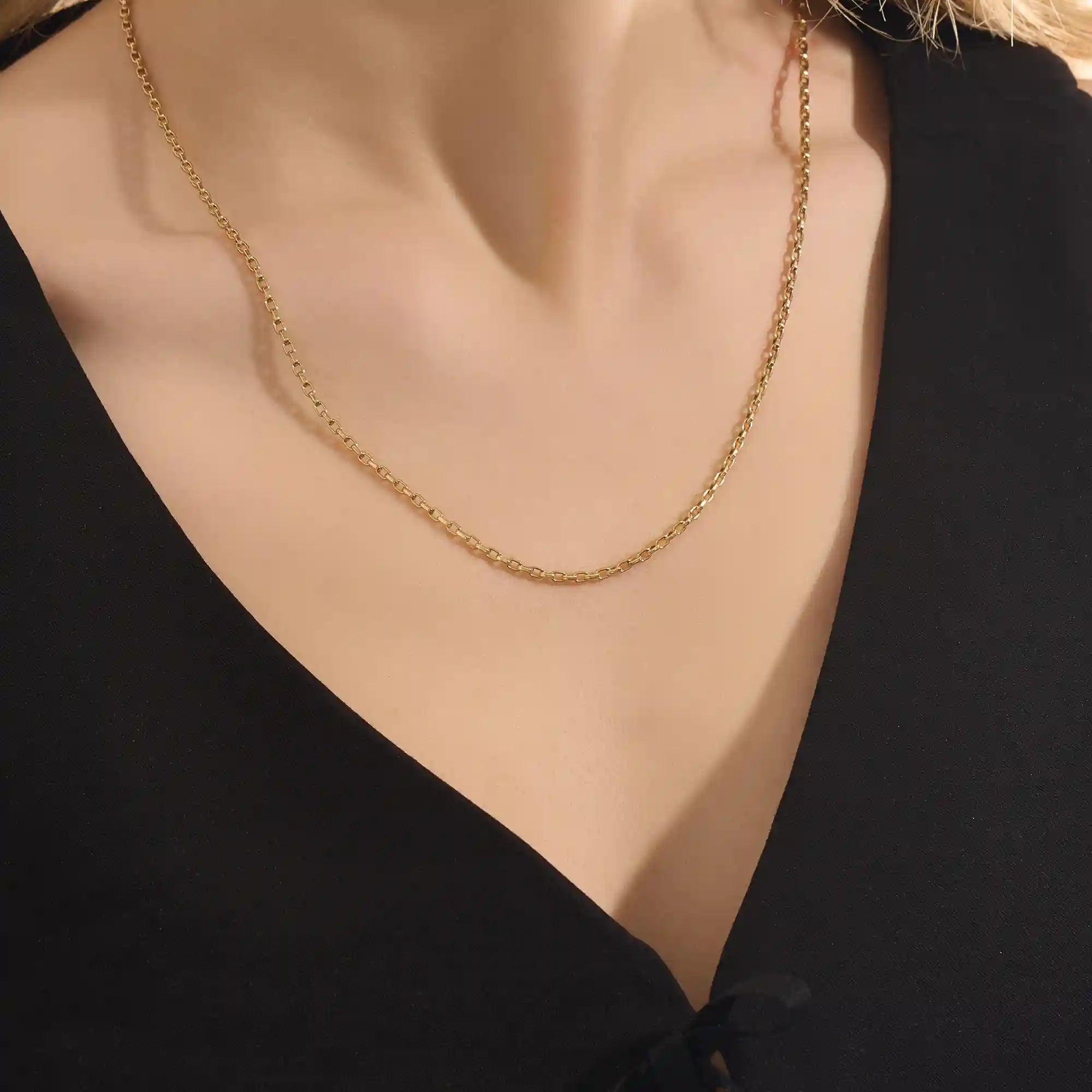 Woman wearing a 14k solid gold rolo chain necklace with smooth round links. A simple yet bold chain for daily outfits. Ideal for layering or wearing solo.