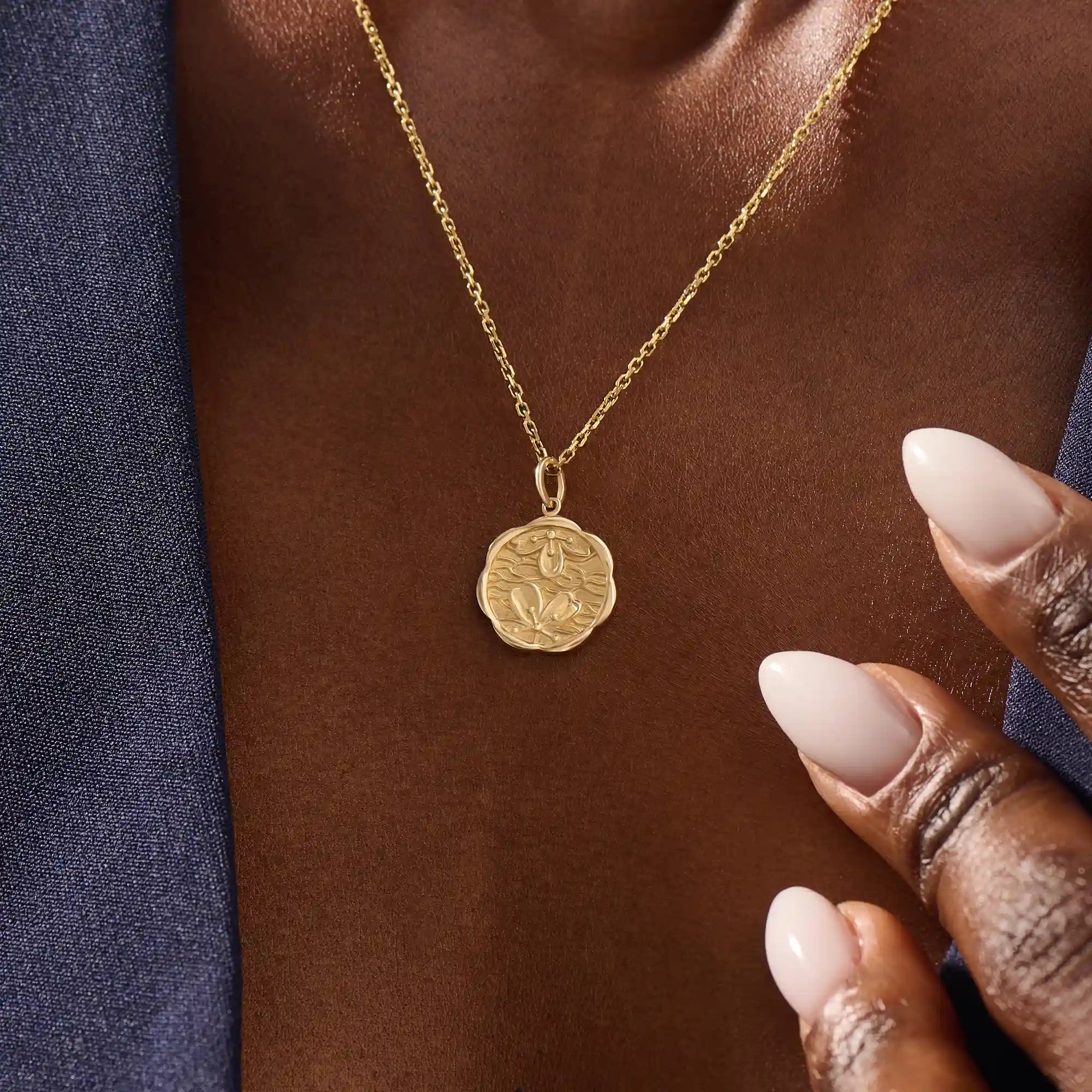 Woman wearing a 14k solid gold round necklace with a Sakura flower motif. Elegant floral-inspired jewelry for women. Perfect for everyday gold layering.