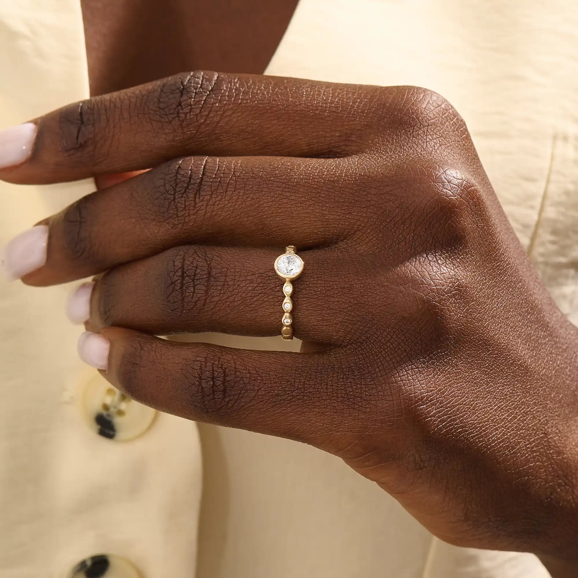 Woman wearing a 14k solid gold solitaire engagement ring with a bezel-set moissanite and fine band details. Elegant and minimal with a unique touch. Ideal for everyday wear and special moments.