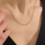 Woman wearing a 14k solid gold textured chain necklace with a soft shimmer. Stylish and easy-to-wear gold chain for daily looks. Perfect on its own or layered.