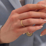 Woman wearing a 14k solid gold vine wedding band with flowing leaf-like engravings. A soft and romantic ring for daily styling. Perfect as a nature-themed or stacking band.