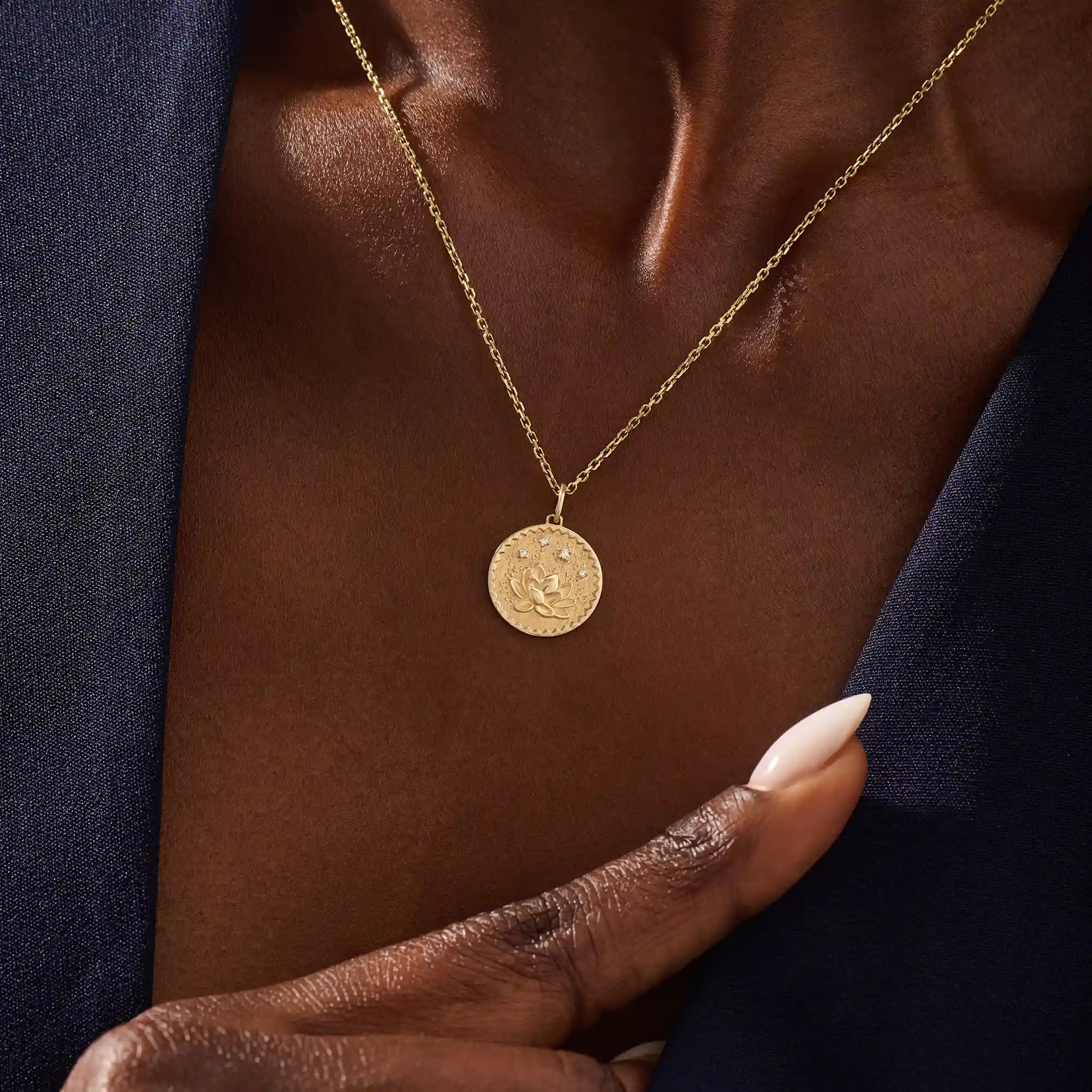 Woman wearing a 14k solid gold water lily pendant necklace with a delicate moissanite accent. Nature-inspired fine jewelry styled for everyday wear. Elegant and minimalist gold necklace for women.