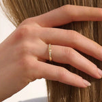 Woman wearing a 14k solid gold wedding band with delicate trio moissanite details. Elegant and meaningful design for daily styling. Great as a wedding or stacking ring.