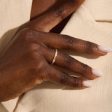 Woman wearing a 14k solid gold wedding band with delicate trio moissanite details. Elegant and meaningful design for daily styling. Great as a wedding or stacking ring.