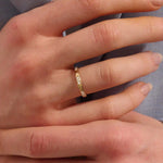 Woman wearing a 14k solid gold wedding band with delicate trio moissanite details. Elegant and meaningful design for daily styling. Great as a wedding or stacking ring.