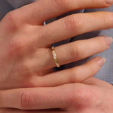 Woman wearing a 14k solid gold wedding band with delicate trio moissanite details. Elegant and meaningful design for daily styling. Great as a wedding or stacking ring.