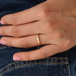 Model wearing a 14k gold vermeil small signet ring with a delicate twisted band design, elegant minimalist jewelry for women.
