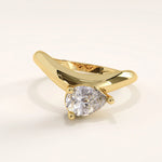 Gold ring with a pear-shaped diamond on a light background