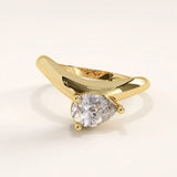 Gold ring with a pear-shaped diamond on a light background
