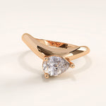 Rose gold ring with a pear-shaped diamond on a light background