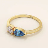 14k gold Toi et Moi ring with pear-shaped sapphire and round moissanite side by side. A symbolic two-stone engagement ring.