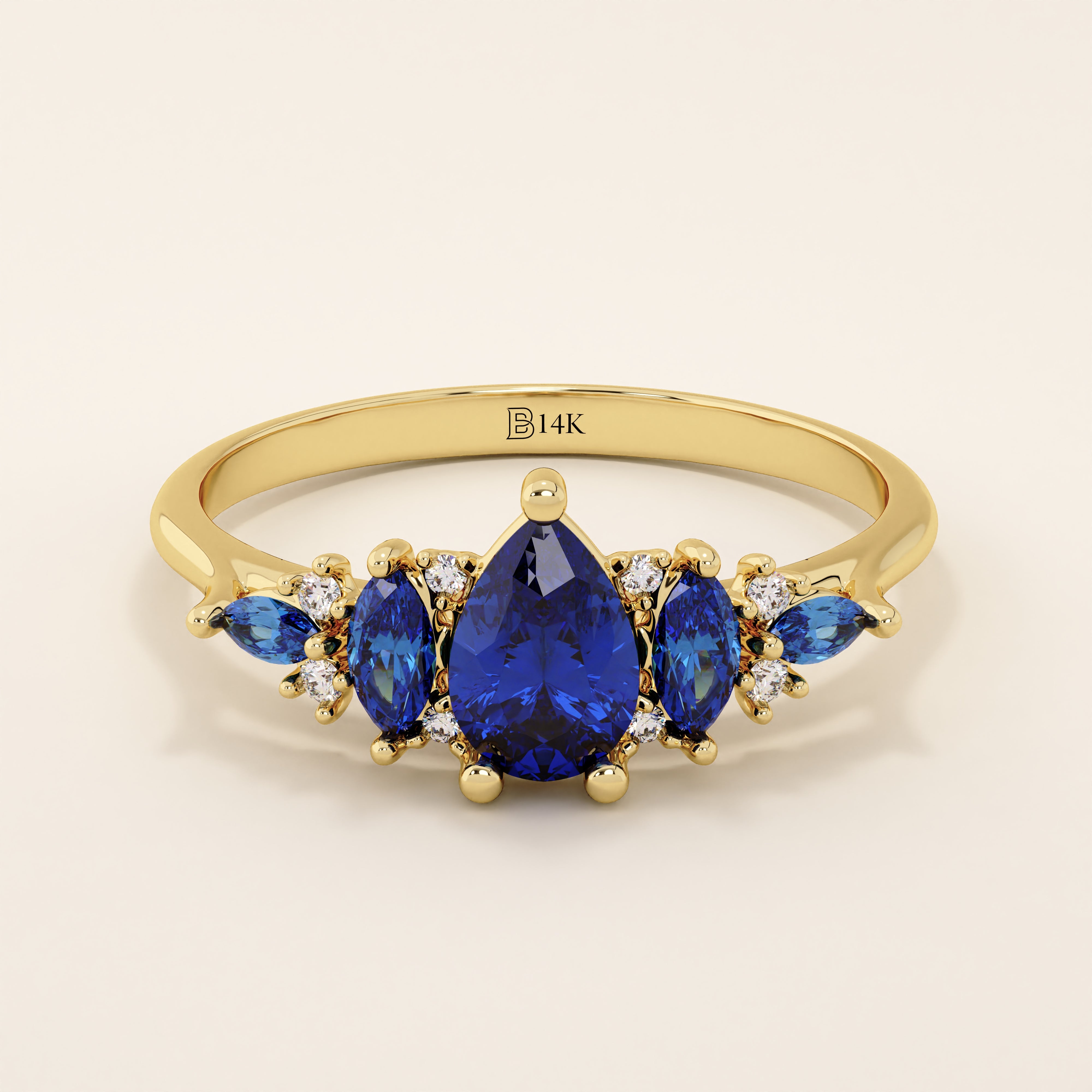 14k gold anniversary ring featuring five pear-cut sapphire gemstones. Elegant and symmetrical gemstone band design.