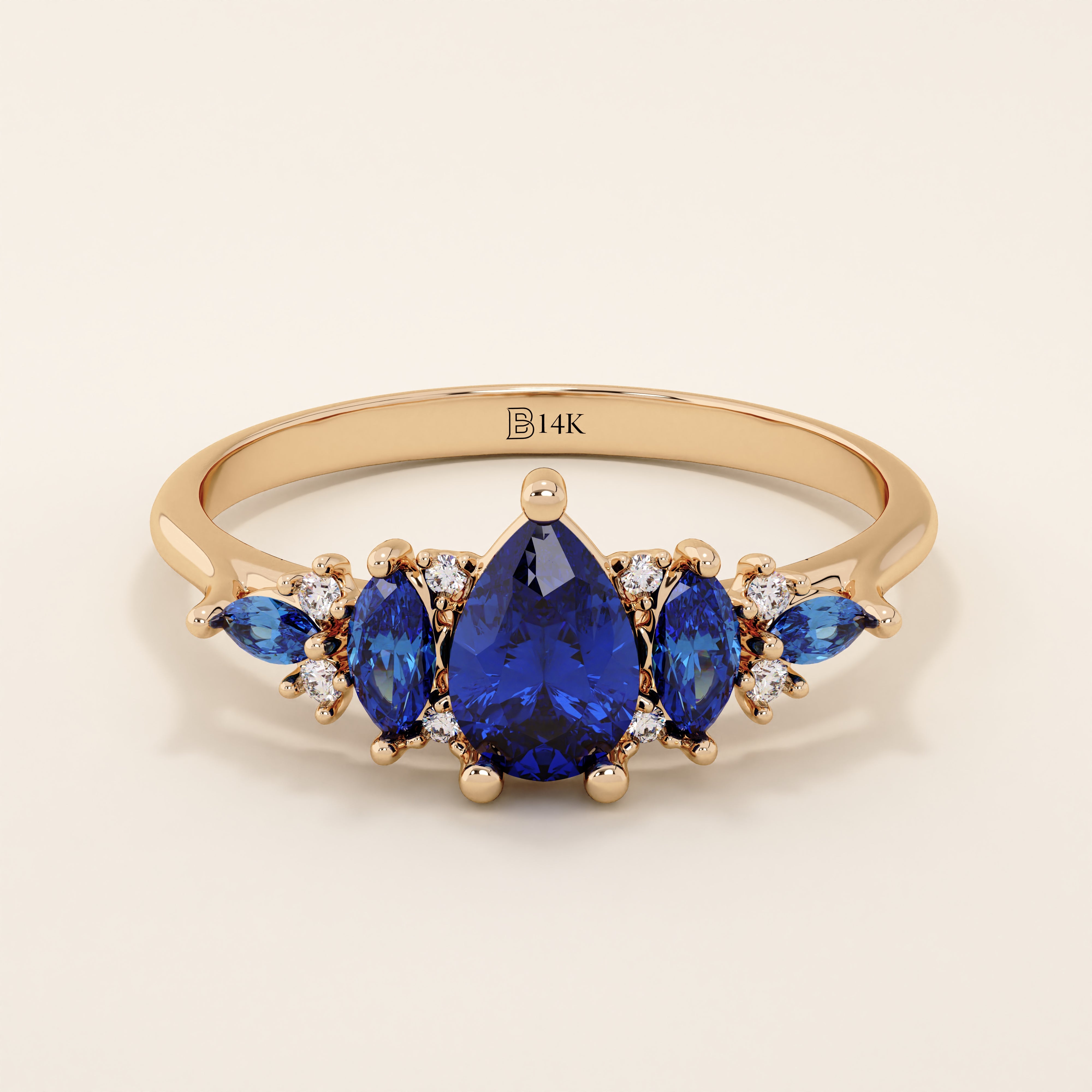 14k gold anniversary ring featuring five pear-cut sapphire gemstones. Elegant and symmetrical gemstone band design.
